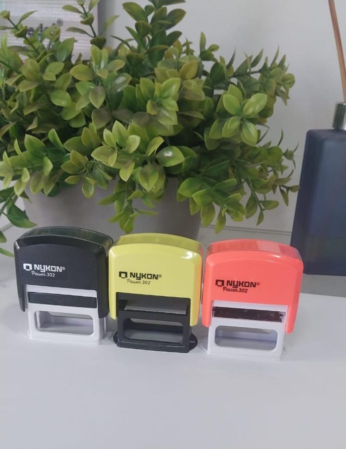 Três carimbos automáticos Nykon Power 302 nas cores preto, amarelo e coral
